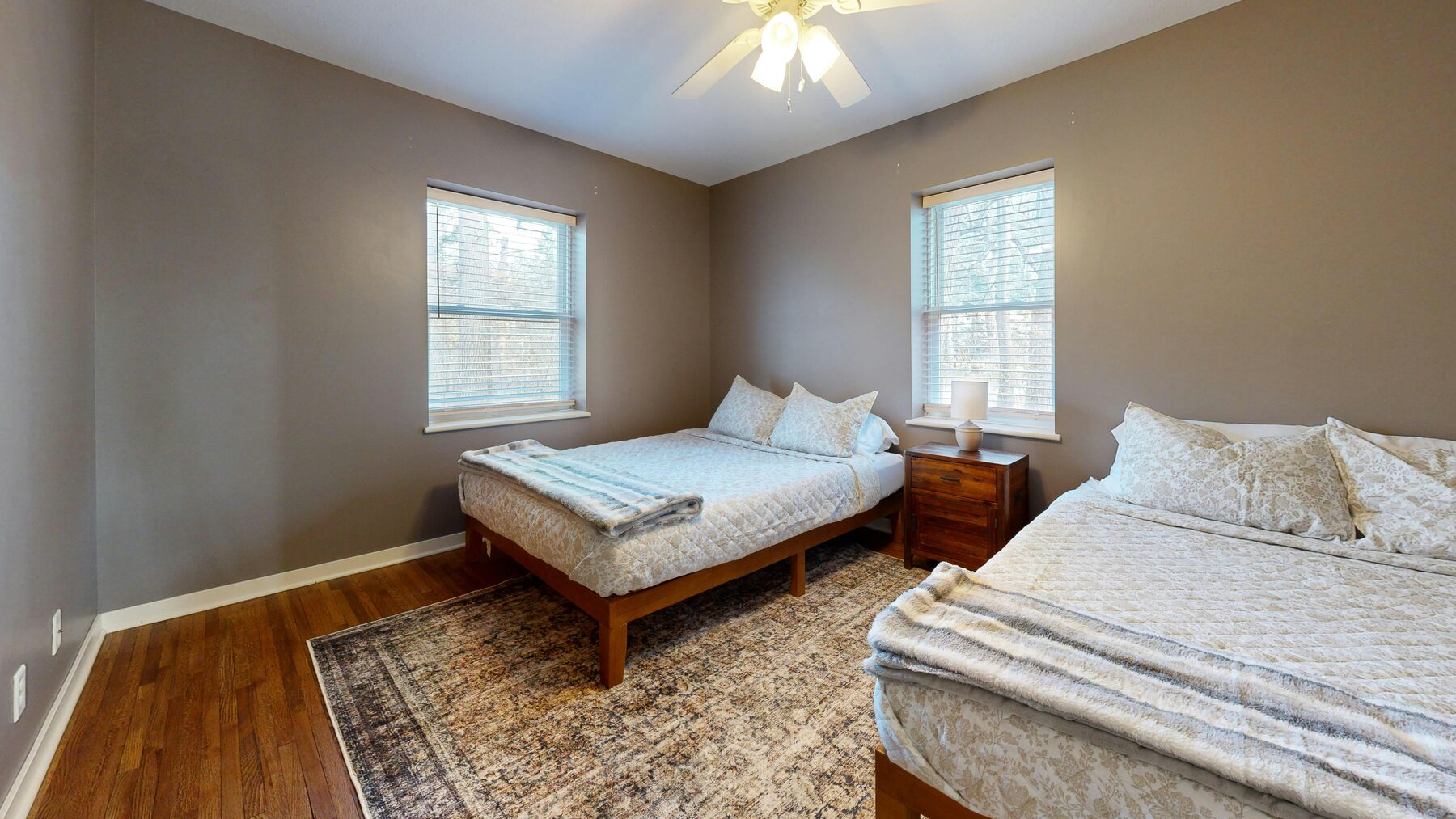 Shared bedroom with two beds and large windows